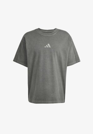 Graues, übergroßes T-Shirt aus Baumwolle, mit kurzen Ärmeln und Rundhalsausschnitt. Es hat ein kleines weißes Adidas-Logo auf der Brust.