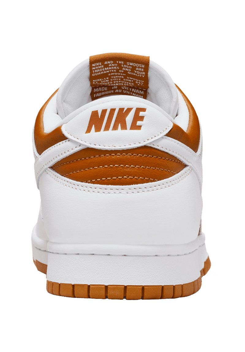 Sneakers en cuir blanc avec des accents orange et des détails texturés. Présentent un col rembourré et une semelle en caoutchouc avec un motif de bande de roulement.