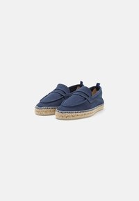 Espadrilles de lona azul marino con suela de yute trenzado, diseño sin cierre, acentos de costura y pequeña lengüeta en el talón para facilitar el uso.