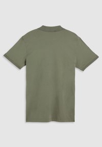 Polo de culoare verde olive, fabricat din bumbac. Mâneci scurte, cu guler și manșete ribbate. Textură netedă, fără modele sau elemente metalice vizibile.