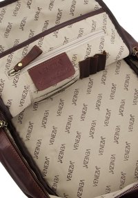 Brun lædertaske indvendigt med en beige foring med et gentaget "Venezia"-logo. Indeholder en lynlåslomme og organisatoriske rum.