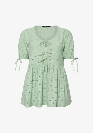 Blouse vert clair en œillets avec manches courtes bouffantes, trois fermetures à nouer sur le devant et taille froncée pour une coupe ample.