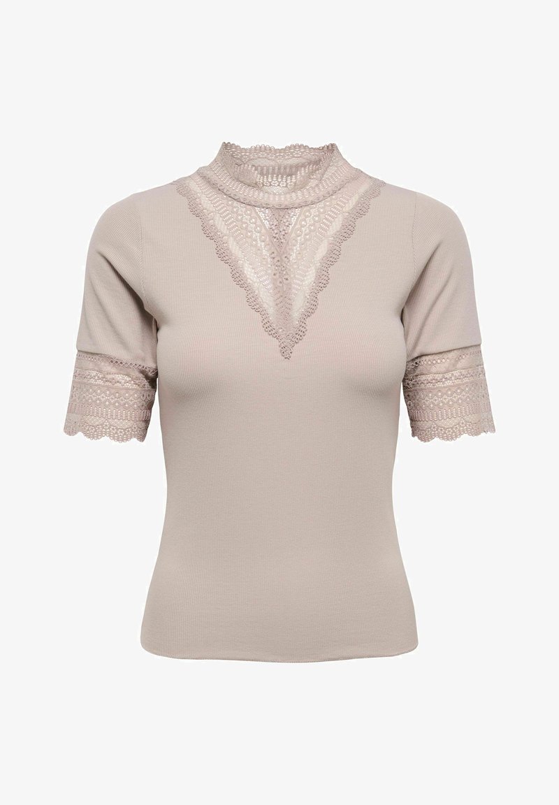Haut à manches courtes beige clair en tissu côtelé, avec bordure en dentelle autour du col montant, en forme de V sur la poitrine, et aux poignets des manches.