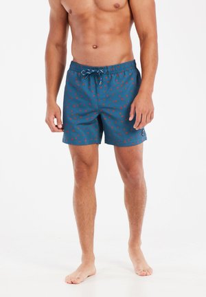 Swim shorts in dark teal fabric with small red patterns, elastic waistband, and drawstring. Smooth texture, above-the-knee length.
