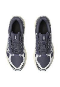 Scarpe da ginnastica navy con tomaia in rete, accenti grigi e motivi testurizzati. Suola arrotondata con una leggera curvatura e tacco rinforzato.