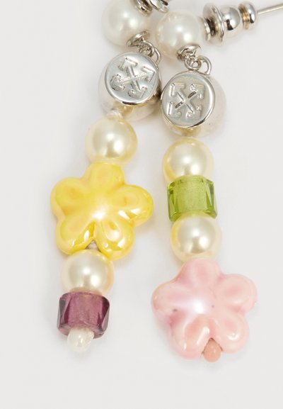 Σκουλαρίκια με ασημένια κουμπιά που φέρουν σχέδια με σταυρό-βέλος, χάντρες μαργαριταριού, χάντρες σε σχήμα κίτρινου και ρόδινου λουλουδιού, καθώς και χάντρες πράσινου και μοβ που μοιάζουν με πολύτιμους λίθους.