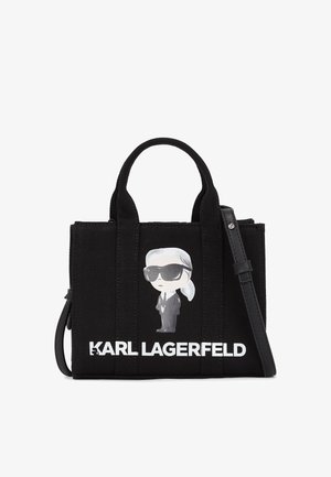 Mustast kangast käekott, mis on varustatud kahe lühikese käepideme ja eemaldatava rihmaga. Sellel on koomiksigraafika kellegi tegelasest ning tekst "KARL LAGERFELD".
