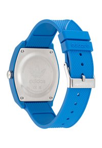 Montre avec bracelet en caoutchouc bleu, boîtier en acier inoxydable carré, matériel argenté, bracelet texturé et logo en relief sur la bande.