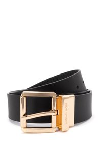Ceinture en cuir noir avec une boucle en métal doré poli. La boucle a une forme rectangulaire et présente une marque gravée. Intérieur texturé.