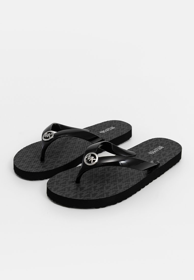 Schwarze Flip-Flops mit einer strukturierten Sohle, glänzenden schwarzen Riemen und einem metallischen Logo-Detail am Riemen. Flaches Design, das sich für die Freizeitkleidung eignet.