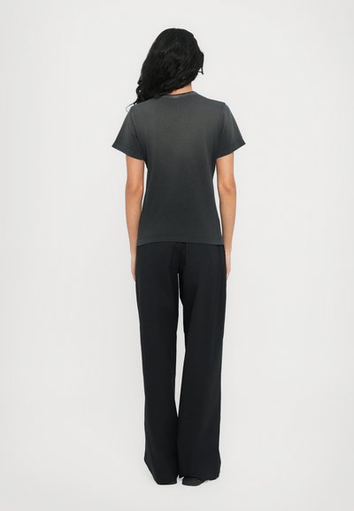 Dark grey short-sleeve t-shirt, cotton material, relaxed fit, paired with black wide-leg trousers, smooth texture, minimalistic design.