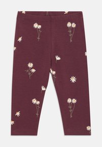 Bordeauxfarbene Leggings aus weichem Stoff, mit verstreuten weißen und gelben Gänseblümchenmustern sowie grünen Stielen.