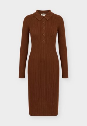 Femme debout portant une robe midi moulante marron côtelée à manches longues avec col et boutons, associée à des bottes hautes marron foncé.