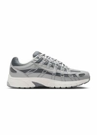 Chaussure de course Nike grise et blanche avec tige en mesh et cuir, fermeture à lacets, et semelle épaisse et amortissante, présentée de profil sur fond blanc.