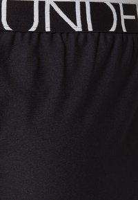 Czarne spodenki sportowe z fakturowaną tkaniną, wyposażone w elastyczny pas z kontrastującymi białymi literami.