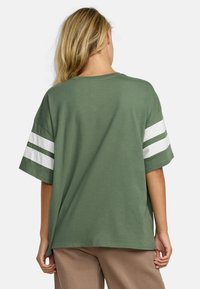 Korte mouwen groene t-shirt met witte gestreepte accenten op de mouwen. Zacht katoenen materiaal, comfortabele pasvorm, ronde halslijn en rechte zoom.