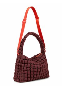 Sac à épaule matelassé bordeaux avec une surface texturée, une poignée arrondie et une sangle et une fermeture éclair réglables de couleur orange vif.