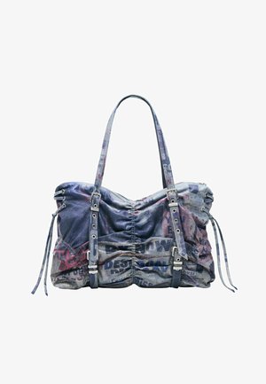 Kék farmer tote táska húzott részletekkel, állítható csattos pántokkal, és kifakult nyomott szövegmintával a textilen.