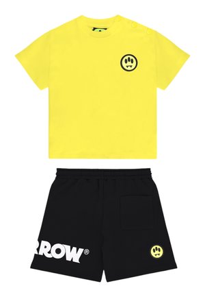 Maglietta gialla a maniche corte con logo di zampa di vampiro nera e pantaloncini neri con vita elastica, testo bianco "ARROW" e toppa con logo coordinato.