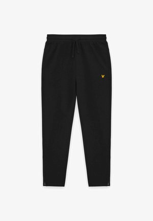Schwarze, schmal zulaufende Jogginghose mit Kordelzugbund, reißverschlossenen Bündchen an den Knöcheln, Seitentaschen und kleinem gelbem Vogel-Logo am rechten Oberschenkel.