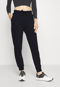 Marina joggingbyxor gjorde av mjukt tyg med elastisk midja och dragsko. Har sidofickor och avsmalnande  ärmslut vid anklarna.