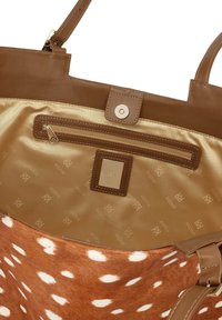 Tamn kožni torba s prednjom stranom od smeđeg i bijelog toka. Unutrašnjost ima zlatnu satin oblogu i zipovski džep.