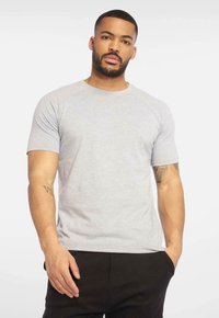 Grå kortærmet t-shirt med et enkelt design, lavet af blødt stof. Har en rund halsudskæring og diskret branding på brystet.