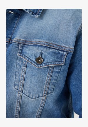 Hellblaues Denim-Jacket mit spitzem Kragen, einer Brusttasche mit einem braunen Knopf und sichtbaren Nähdetails.