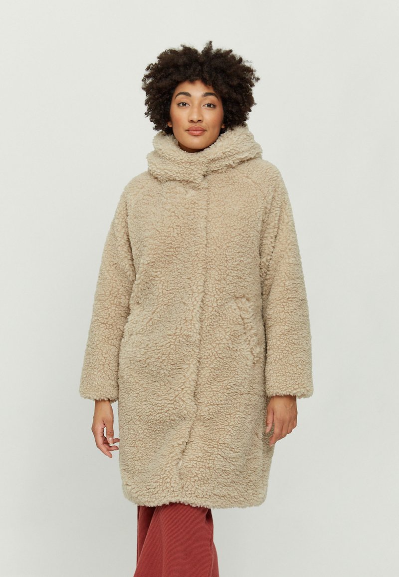 Beige, plush, fur-like coat with a high collar and long sleeves, featuring two front pockets and a straight cut design.