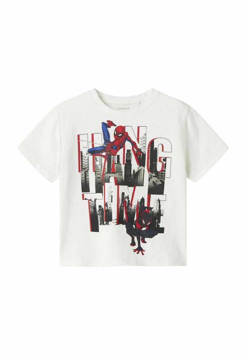 T-shirt en coton blanc présentant des graphiques de Spider-Man rouges et noirs avec le texte "HANG TIME", sur fond de skyline urbain.