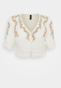 Blusa bianca corta con maniche corte a volant, decorata con ricami floreali colorati in arancione e verde, e chiusura frontale con bottoni.
