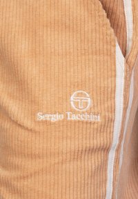 Lichtoranje corduroy kledingstuk met een wit logo "Sergio Tacchini" en witte afwerking, met een verticale ribstructuur.