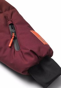 Manica isolata bordeaux con polsino elasticizzato, caratterizzata da un'etichetta logo arancione e una fodera interna nera. Zip con tirante arancione per una chiusura sicura.