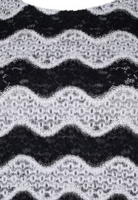 Dzianina swetra z zygzakiem w naprzemiennie czarnym i szarym, z wyraźną, puszystą fakturą oraz wzorem przypominającym koronkę.