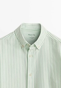 Lichtgroen en wit gestreepte button-up shirt gemaakt van zachte stof. Heeft een klassieke kraag en parelachtige knopen, met een label aan de binnenkant.