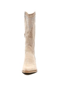 Bota de cowboy de ante beige con cortes abiertos y acentos decorativos en plata. Presenta una puntera puntiaguda y un borde superior contorneado.
