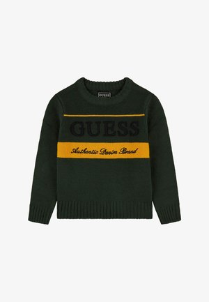 Ciemnozielony dzianinowy sweter z prążkowanymi krawędziami, z żółtym poziomym paskiem i czarnym napisem „GUESS Authentic Denim Brand” na przodzie.