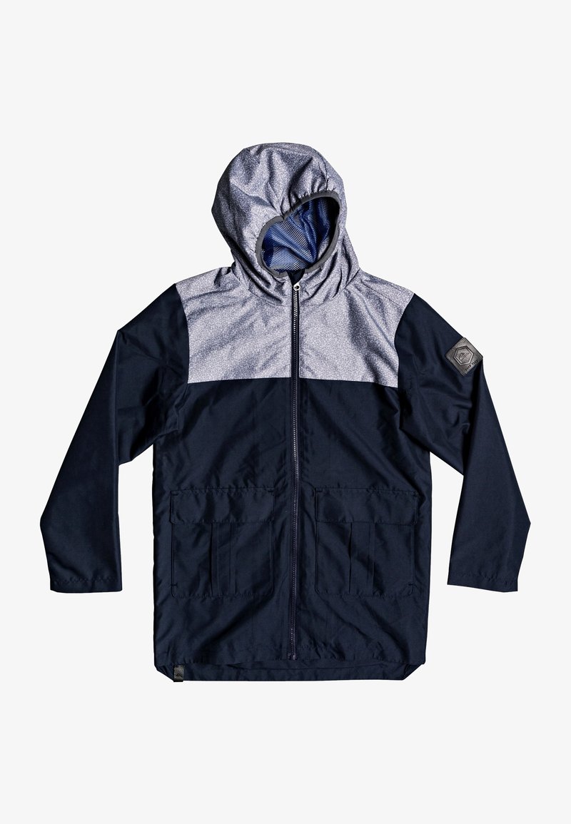 Veste à capuche avec fermeture éclair à l'avant, corps bleu marine foncé, partie supérieure gris clair, deux poches avant et un écusson sur la manche gauche.