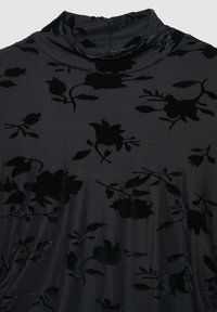 Tessuto nero a motivo floreale con una consistenza morbida e vellutata. Il design presenta diversi motivi di rose su uno sfondo scuro. Collo alto.