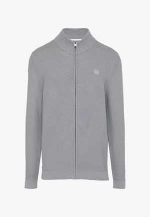 Halli halli kasukaga, millel on kõrge krae, pehme tekstuur ja väike logo plaastriga vasakul rinnal.