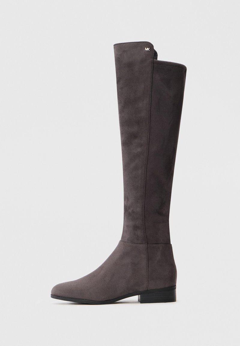 Bota de camurça cinza escuro até ao joelho, com salto baixo e logotipo metálico discreto perto do topo, sobre fundo claro.