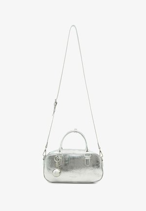 Zilverkleurige metallic handtas met een gladde textuur, afgeronde vorm, dubbele handvatten, afneembare band en een decoratieve ronde hanger eraan bevestigd.
