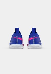 Dvojice modrých a růžových atletických bot Nike Air Zoom Mercurial zobrazená zezadu na bílém pozadí.