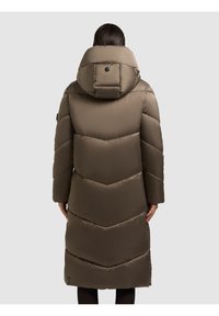 Hnědý oteplený kabát s kapucí, s šípovým vzorem, hladkouTexturou a knoflíkovým detailem na zadní straně, dosahující délky do půli lýtek.