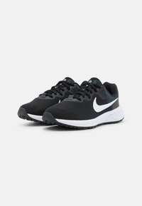 Zapatos deportivos negros con una parte superior de malla transpirable, acentos blancos y una suela acolchada, que cuentan con una suela de goma texturizada para mayor tracción.