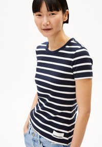 Camiseta de manga corta a rayas en navy y blanco, fabricada en tejido acanalado, con un cuello redondo y una pequeña etiqueta de marca cerca del dobladillo.