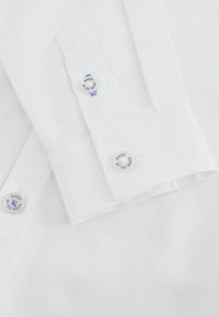 Weißes Hemd mit strukturiertem Stoff, mit geknöpften Manschetten und markenprächtigen Knöpfen mit der Aufschrift "Baker by Ted Baker". Enthält dezente blaue Akzente.