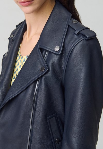 Veste en cuir bleu marine avec une finition texturée, dotée d'un col cranté, de quincaillerie en argent et d'une fermeture éclair sur le devant.