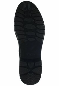 Sole di scarpa in gomma nera con superficie testurizzata e motivi a impronta ellittica e circolare per una migliore aderenza e trazione.