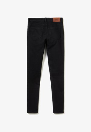 Jeans skinny en denim noir avec une texture lisse, présentant une étiquette en cuir à la taille et deux poches arrière. Aucune poche avant visible.